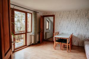 a room with a table and chairs and a window at Cisówka Pokoje Gościnne in Piwniczna-Zdrój