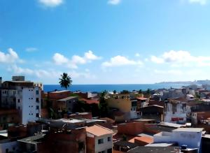 a city with buildings and the ocean in the background at pousada mar azul in Salvador