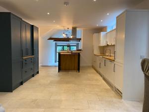 a large kitchen with white cabinets and a kitchen island at Number Forty One in Sudbury
