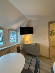 a living room with a table and a tv on the wall at K&K Apartamenty in Świdwin