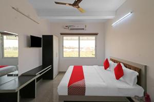 ein Schlafzimmer mit einem Bett mit roten Kissen in der Unterkunft Hotel O Safari Inn in Hāpur + 23 Fotos