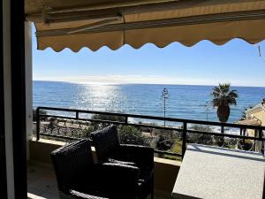 un balcone con tavolo e sedie e l'oceano di Glyfada Menigos Apartment 21 a Glifada (Glyfada)
