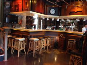 a bar with bar stools and a clock on the wall at Glendale Hotel in Cardiff