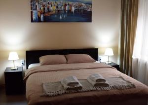 a bedroom with a large bed with two towels on it at AeroVista Apartment in Surčin