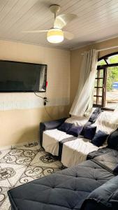 une chambre avec deux lits et une télévision à écran plat dans l'établissement Casa na Vila do Abraão - Ilha Grande, à Angra dos Reis
