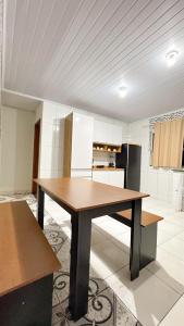 une cuisine avec une table en bois dans une pièce dans l'établissement Casa na Vila do Abraão - Ilha Grande, à Angra dos Reis