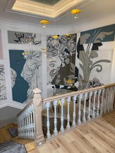 a mural on the wall of a room with a staircase at House4You - Praporgescu in Bucharest