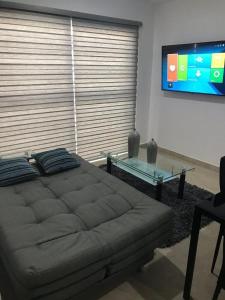 1 dormitorio con 1 cama grande y mesa de cristal en Departamento en Mazatlán, en Mazatlán