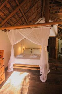 a bedroom with a bed with mosquito nets on it at Quinta de Caraíva in Porto Seguro