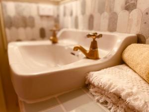 ein weißes Badezimmer mit Waschbecken und Badewanne in der Unterkunft The Botanist in New Plymouth + 10 Fotos