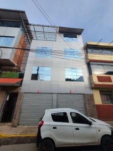 a white car parked in front of a building at Hospedaje Casa Huayra in Cusco