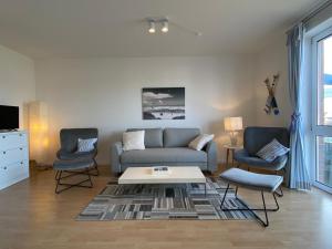 un soggiorno con un divano e due poltrone di Simmerdeis am Hafen a Husum Altre 26 foto