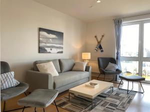 un soggiorno con un divano, sedie e un tavolo di Simmerdeis am Hafen a Husum