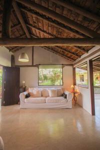 a living room with a white couch in a room at Pousada Quinta de Caraíva in Porto Seguro