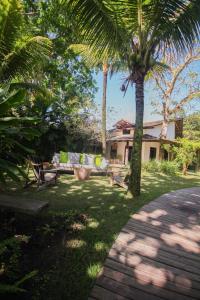 a garden with palm trees in front of a house at Pousada Quinta de Caraíva in Porto Seguro