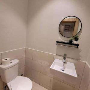 a bathroom with a white toilet and a mirror at Alfredo Suites-Lekki in Lekki