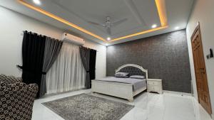 a bedroom with a bed and a couch in it at Heston Villa Islamabad International Airport in Islamabad