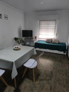 a bedroom with a bed and a table and chair at Geminis in San Nicolás de los Arroyos
