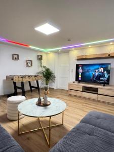 a living room with a tv and a couch and a table at Family & Friends Hannover 75m2, Messe in Hannover