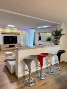 a kitchen with a bar with two red stools at Family & Friends Hannover 75m2, Messe in Hannover