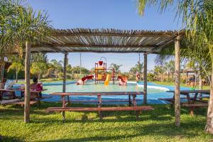 a pool with a picnic table and a playground at Mar de Sueños - Complejo Turístico y Parque Acuático in Paraná
