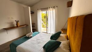 a bedroom with a large bed with a window at hotel Tayrona Angel Lodge cerca a la entrada el zaino parque nacional tayrona in El Zaino