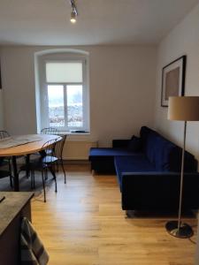 a living room with a blue couch and a table at W Izerach - Apartament Superior in Szklarska Poręba +30 photos