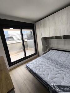 a bed in a room with a large window at Estudios Homer y Disney con piscina climatizada, piscina exterior,gimnasio, coworking, padel,Netflix y wifi gratis in San Sebastián de los Reyes