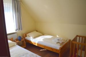una piccola camera da letto con due letti e una finestra di Geräumige 3-Zimmer Wohnung in ruhiger Lage a Wyk auf Föhr