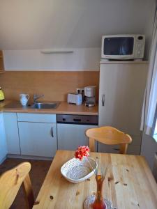 una cucina con tavolo in legno e vaso di fiori di Geräumige 3-Zimmer Wohnung in ruhiger Lage a Wyk auf Föhr Altre 2 foto