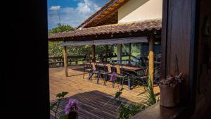 a wooden deck with a table and chairs on it at Casa Mirante da Serra em Tiradentes - MG in Tiradentes