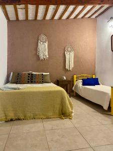 a bedroom with two beds and chandeliers on the wall at Villa Tequila-Casa Frida in Alta Gracia