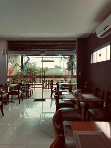 a restaurant with tables and chairs and a large window at PUMMA BUDGET HOTEL in Canaã dos Carajás