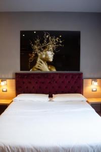 uma cama com uma cabeceira com uma estátua por trás em BeB Umberto I Napoli em Nápoles