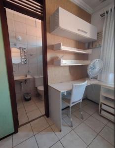 un piccolo bagno con scrivania e servizi igienici di Quarto em casa de Família a Fortaleza