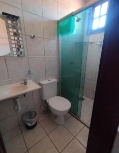 un bagno con wc e doccia in vetro di Quarto em casa de Família a Fortaleza