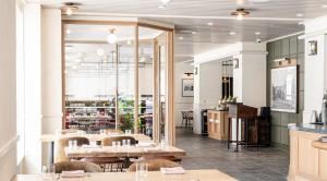 a restaurant with a table and chairs and a mirror at Hotel Heron Alexandria Old Town, Curio Collection by Hilton in Alexandria