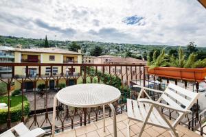 Un patio con una mesa y sillas en un balcón. en Achilla 2 appartamenti, en Torri del Benaco