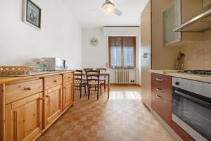 Una cocina con gabinetes de madera y una mesa con sillas. en Achilla 2 appartamenti, en Torri del Benaco