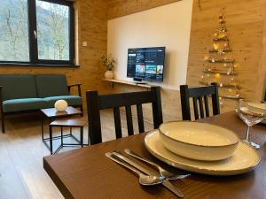 a dining room with a table and a christmas tree at Chalet muguet & Jaccuzi privatif in Rochesson