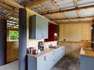 a kitchen with white cabinets and wooden walls at Schlafen im Heu - Familienabenteuer mit Lagerfeuer & Sternenhimmel in Burow