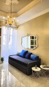 una camera da letto con letto, cuscini blu e specchio di Rome Boulevard Suite a Roma