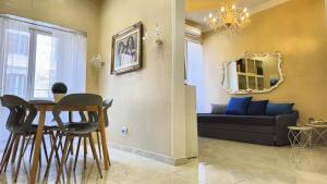 un soggiorno con un divano, un tavolo e delle sedie di Rome Boulevard Suite a Roma
