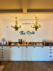 ペーニャにあるThe Reds Pousadaの白いキャビネットと「nets」と書かれた看板のあるキッチン