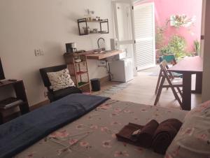 a bedroom with a bed and a kitchen with a table at Estudio do Alto 2 in Sao Paulo