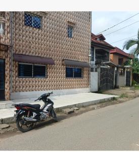 a motorcycle parked in front of a house at chambre meublé Douala bonapriso Cameroun, eau chaude, clim, gardien, wifi haut débit in Douala