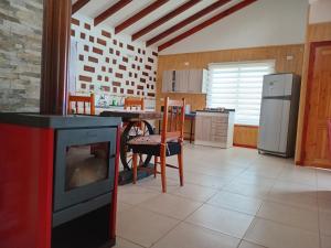 a kitchen with a stove and a table with chairs at El Avellano II in Frutillar