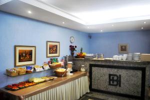 a buffet line in a restaurant with food on display at Hotel Brigadeiro in São Paulo