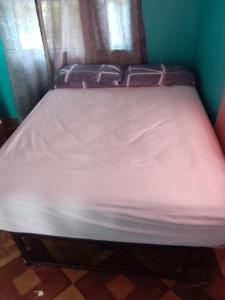 a bed in a room with a white mattress at BBV Properties in Belmont