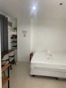 a bedroom with a bed and a table and a desk at Cityscape Tower 2 Condo in Midtown Cebu in Cebu City